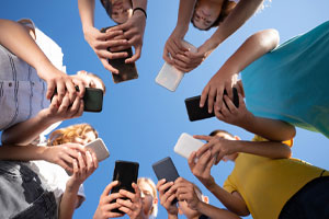 teens in circle on phones